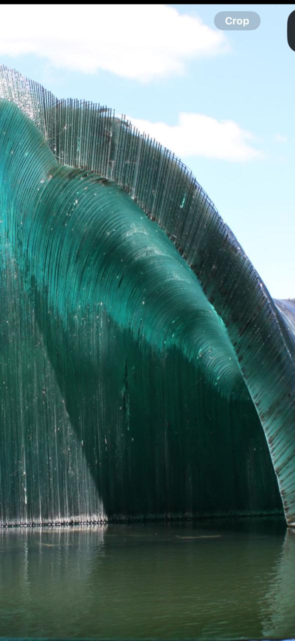 Original green glass wave sculpture outdoors